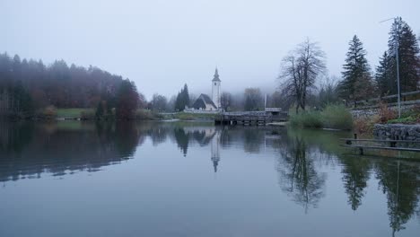 Morgennebel-Am-Bohinjer-See-Mit-Einer-Vollkommen-Stillen-Reflexion-Der-Bohinjer-Kirche-Und-Des-Sees