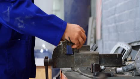 mechanic using bench vises in garage 4k
