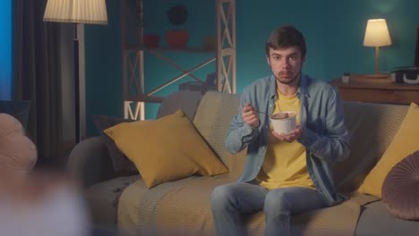young man eating ice cream on the sofa