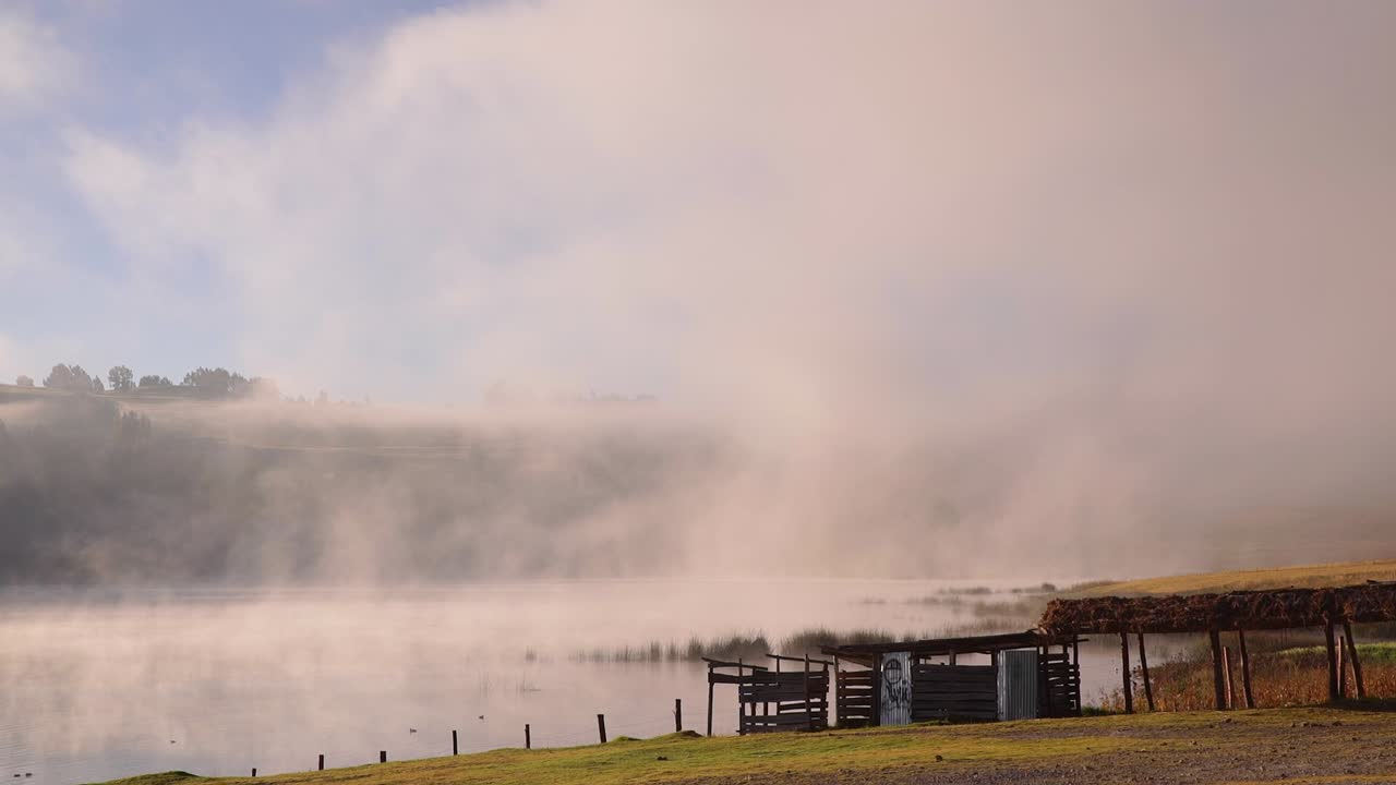 성스러운 계곡에서 겨울의 이른 아침 시간에 물 위로 안개가 불고, 푸른 하늘과 함께 쿠스코 잠긴 샷