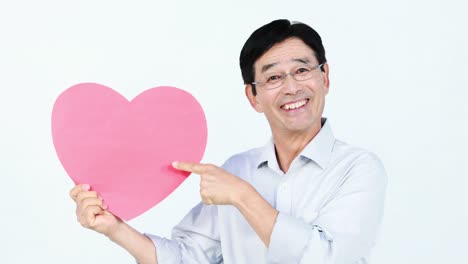Smiling-Asian-man-holding-a-pink-heart