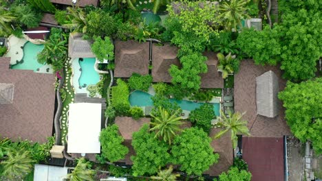 aerial-zoom-out-of-tropical-pool-villas-on-Gili-Trawangan-Island-surrounded-by-coconut-trees