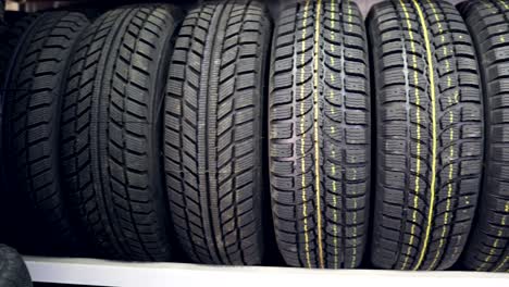 many new winter tires on shelves and in columns. panorama of the store.