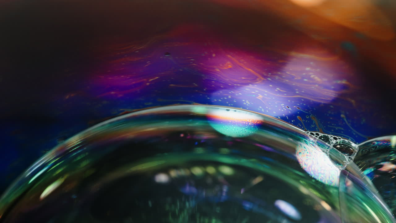 Colorful macro shot of a soap bubble with rainbow patterns and reflections in the background