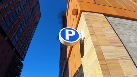 The-camera-arcs-right-around-the-sign-for-a-designated-parking-structure-in-downtown-Tempe,-Arizona