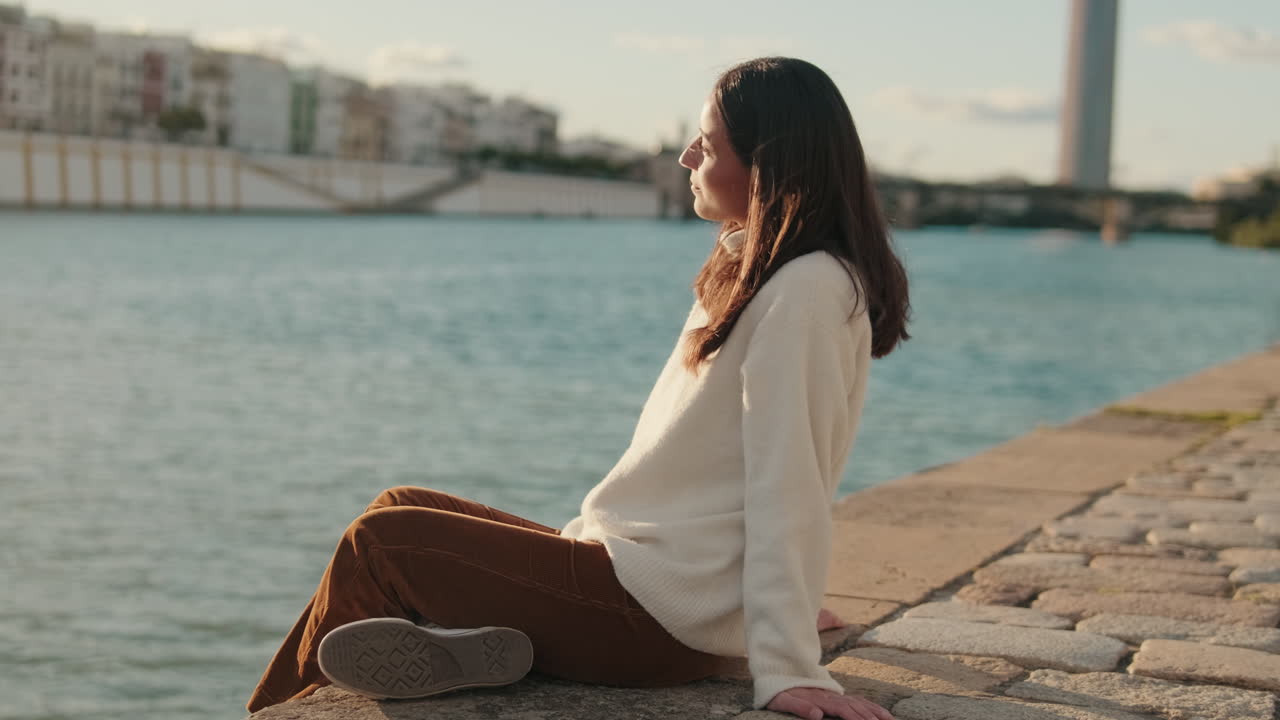 Woman Enjoys Seville Riverside Sunset