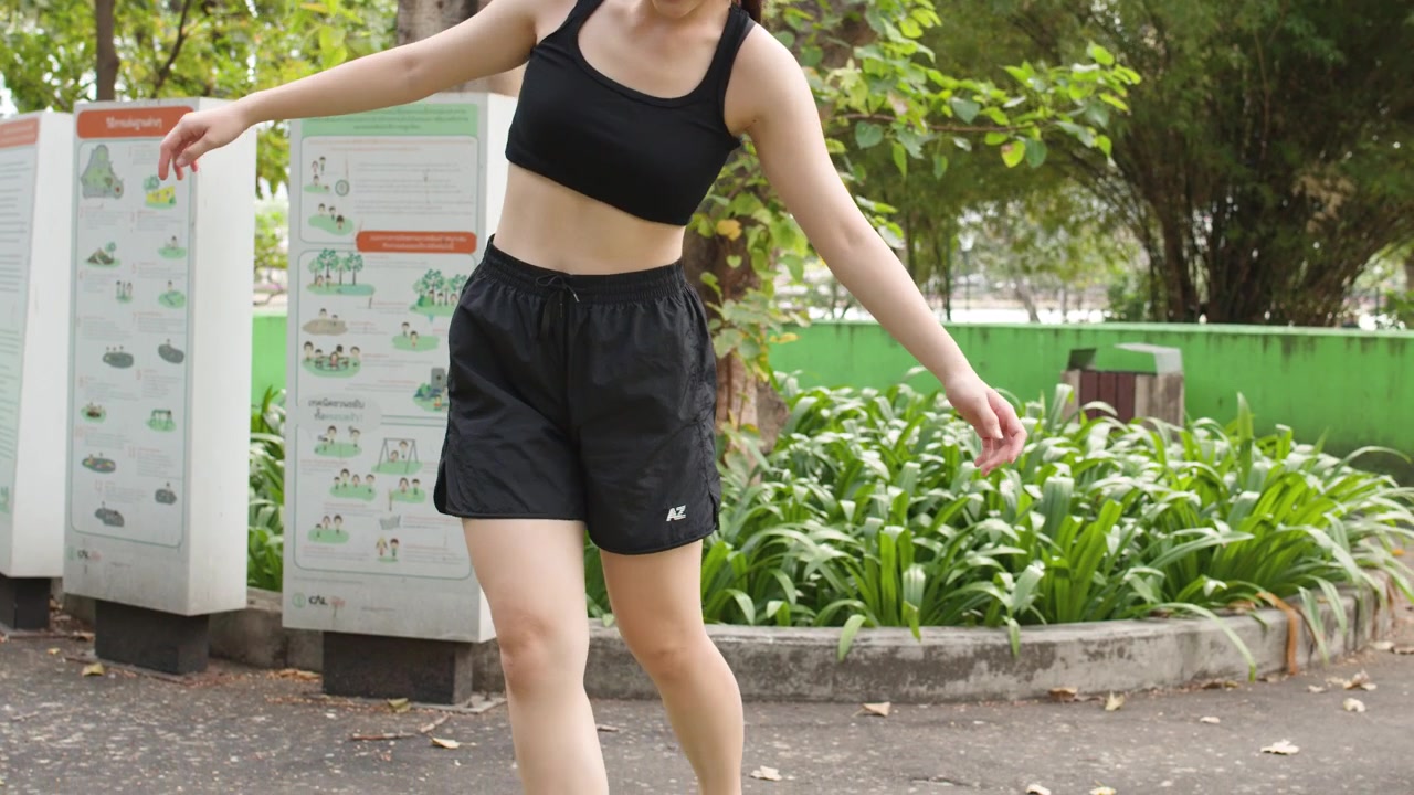 Young Woman Balancing on a Beam in a Park