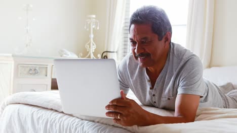 Senior-man-using-laptop-in-bedroom-4k
