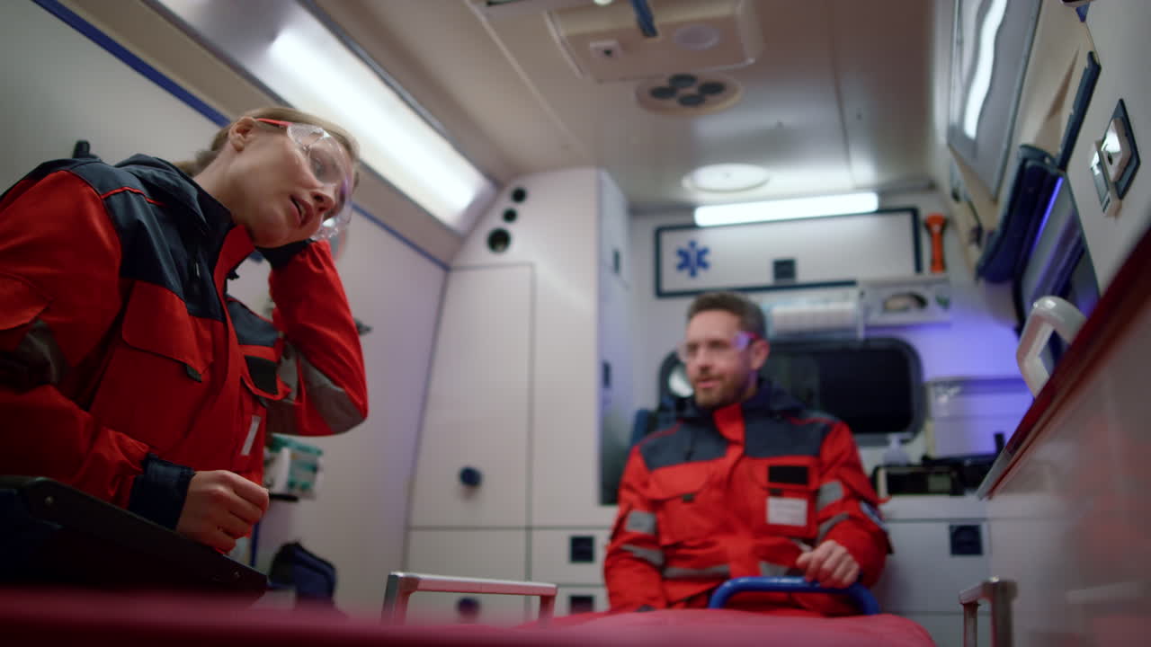 의료 전문가 들 이 구급차 에서 응급 전화 를 받기 위해 가고 있다