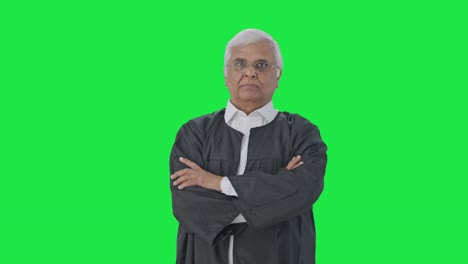 Indian-senior-lawyer-standing-crossed-hands-Green-screen