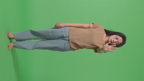 몸에 이 있는 젊은 아시아 여성의 몸이 카메라를 바라보고 녹색 스크린 배경 스튜디오에서 폭력을 멈추기 위해 손 표시를 보여줍니다.