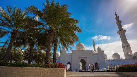 blue sunny sky abu dhabi grand mosque front palm tree entrance 4k timelapse uae