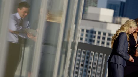 multi ethnic business colleagues using touchscreen on rooftop