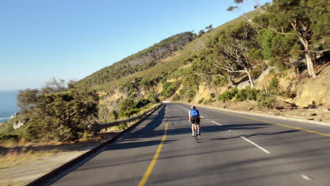 healthy man cycling road bicycle outdoors fitness steadicam shot