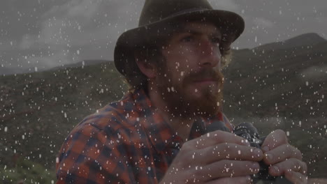 man holding binoculars scanning snowy hills for technology briefing, with floating data charts