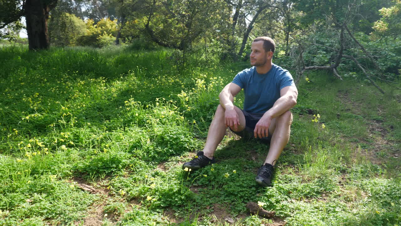 Man Sitting in a Grassy Forest