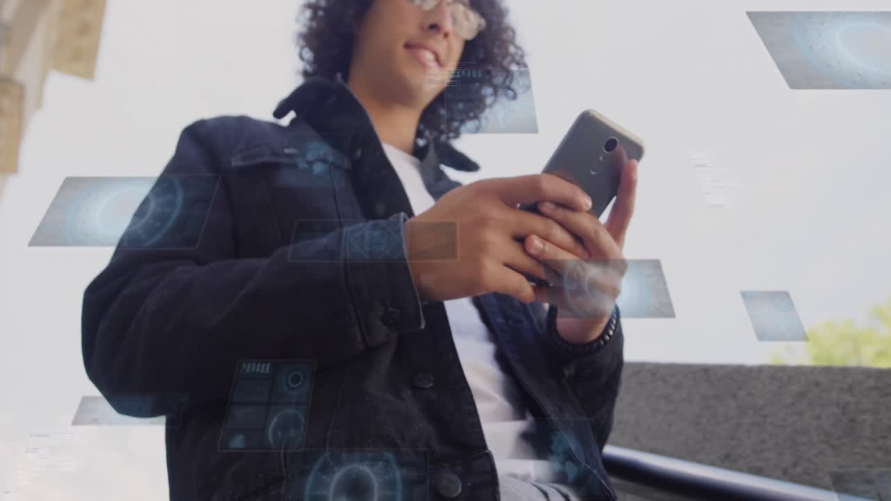 animación de radares y círculos de carga sobre vista de ángulo bajo de hombre biracial usando teléfono celular.