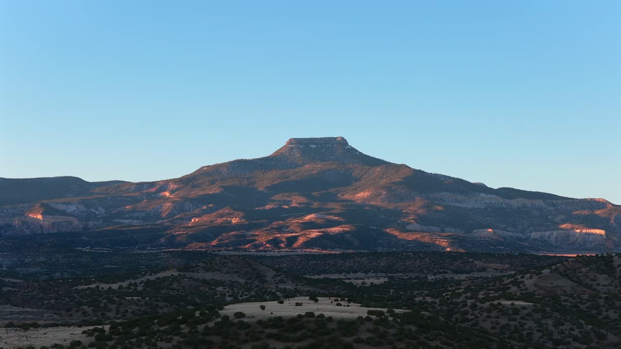 Wide drone view of Abiquiu Lake and a flat-top mountain in the New Mexico desert. A cinematic background plate for travel, nature, or science fiction