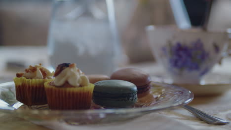 pan across plate of pastries while stirring a cup of tea