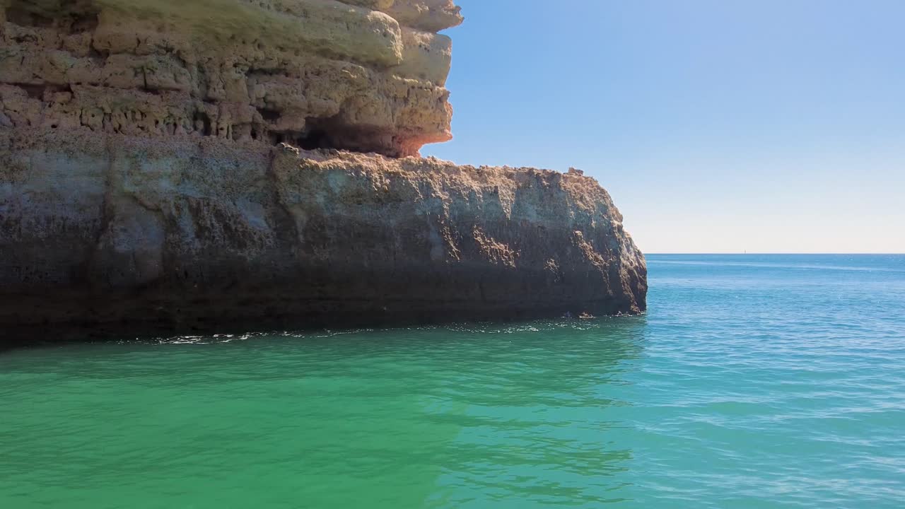 desde un barco una toma de revelación de 4k de las cuevas y acantilados de la costa del algarve de portugal mirando hacia el oeste hacia vilamoura