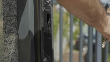 close up of caucasian hand opening metal gate with key, in 4k, slow motion