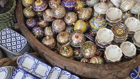 a vibrant collection of intricately designed ceramic bowls and plates in a market setting.