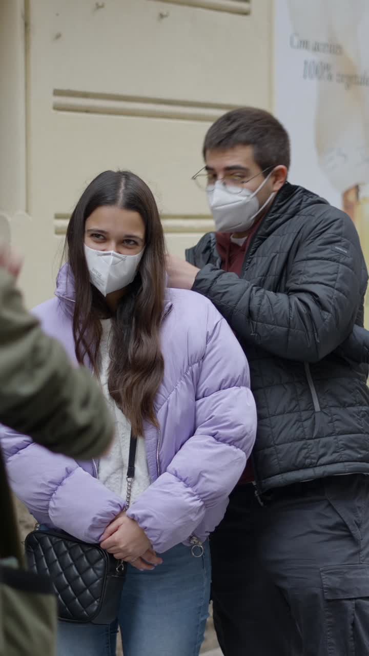 People in face masks interacting on a city street