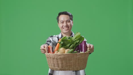 신선한 채소 바구니를 들고 있는 남자