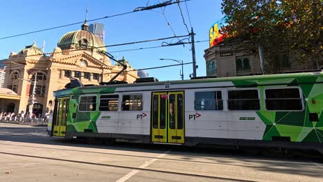 un tranvía se mueve a través de una concurrida intersección de melbourne