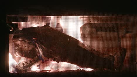 Wood-burning-and-crackling-in-old-cast-iron-fireplace-in-cabin