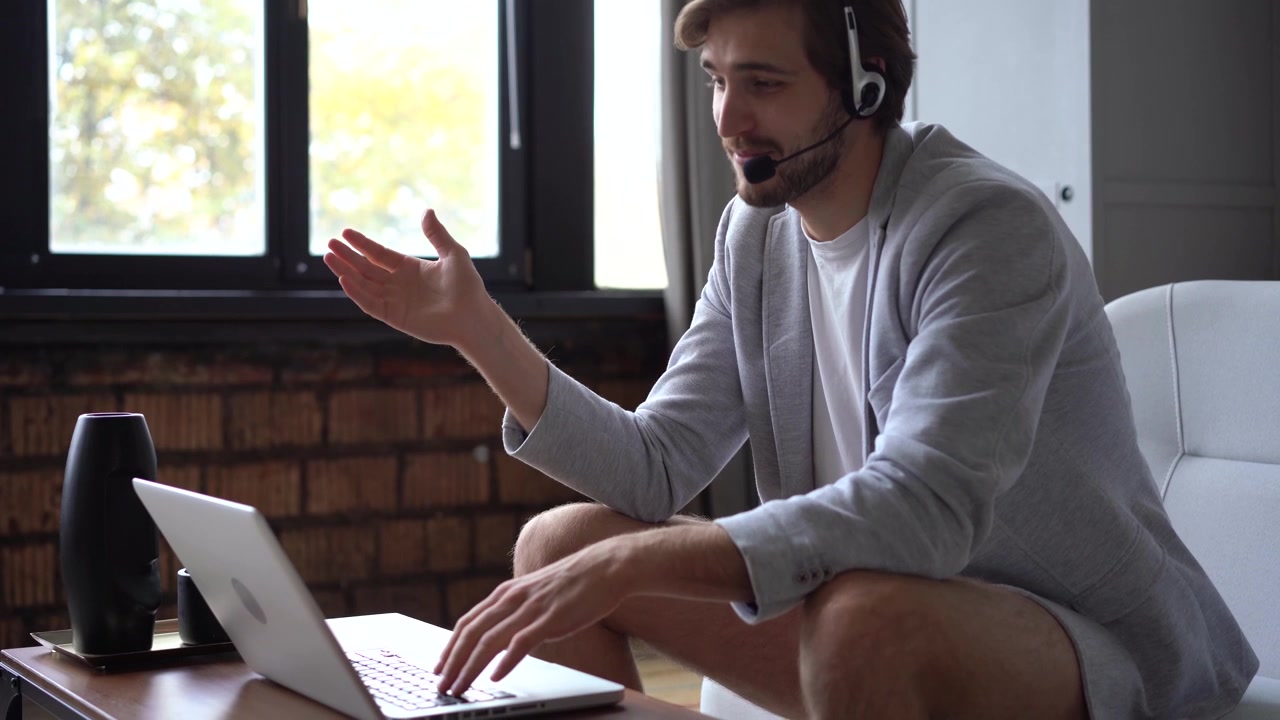 Ung Mand Har et Videoopkald på Bærbar Computer Hjemme
