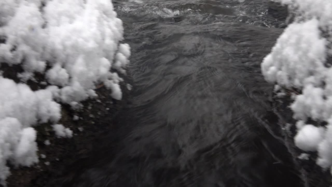 Fiume che scorre attraverso un paesaggio invernale innevato