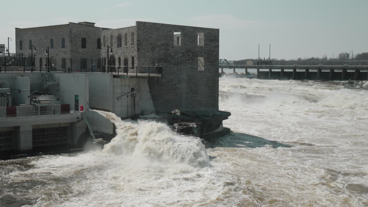Chaudière Island Hydro electric dam and power generation buildings with ragging river waters flowing through it during the end of flood season in Ottawa, Canada