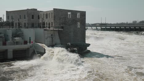 chaudière island hydro electric dam and power generation buildings with ragging river waters flowing through it during the end of flood season in ottawa, canada