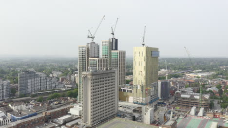 Drone-Aerial-shot-of-Woking-Cityscape-a-town-in-England-with-high-rise-skyscrapers-and-cranes-building-works-with-drone-tracking-zooming-in