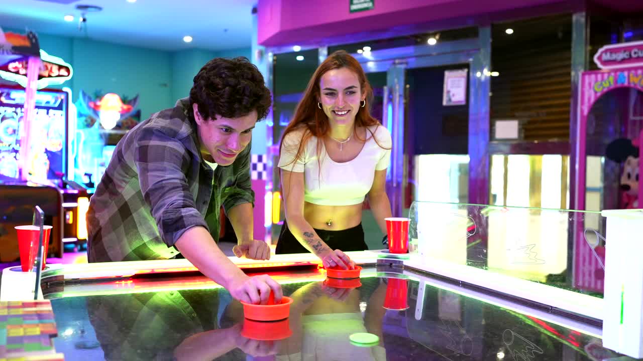 Couple Playing Air Hockey in Arcade