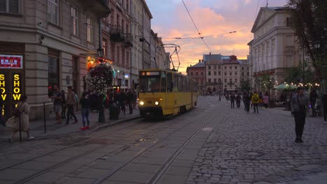sunset in a european city with a yellow tram