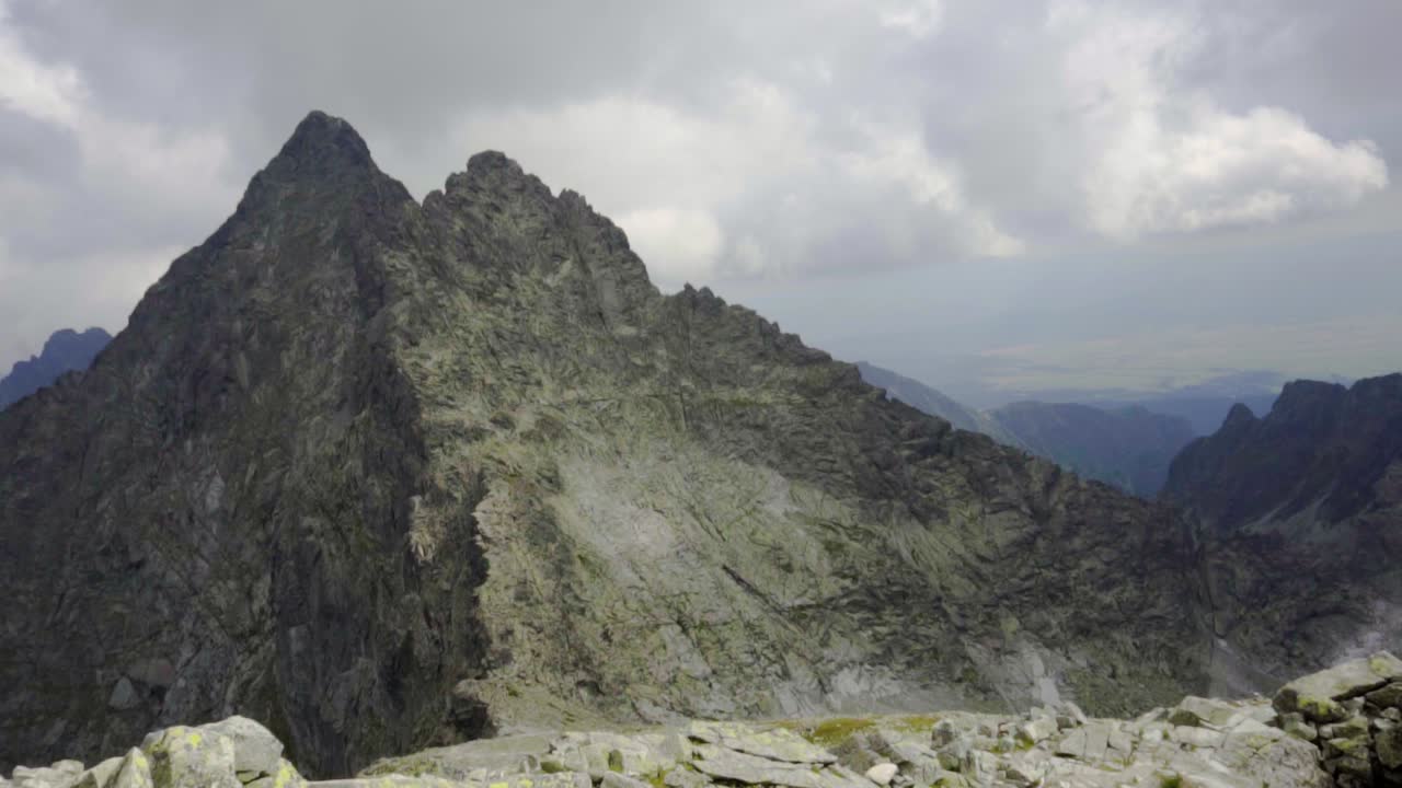 frío pico de montaña en las nubes con un entorno rocoso y un paisaje épico