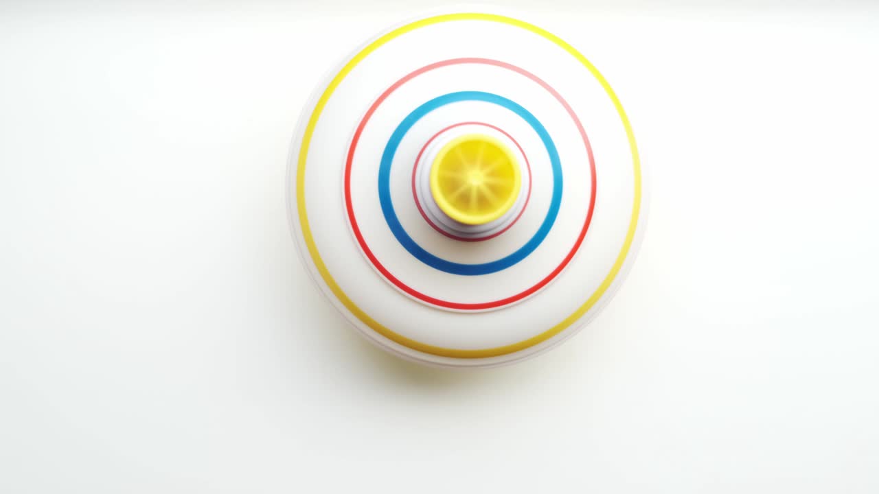 색 배경에서 회전하는 어린이 장난감 회전. 위쪽에서 볼 수 있습니다.