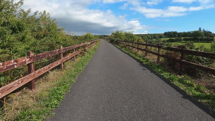 Viaggio POV su pista ciclabile in ghiaia recintata nella bucolica campagna verde
