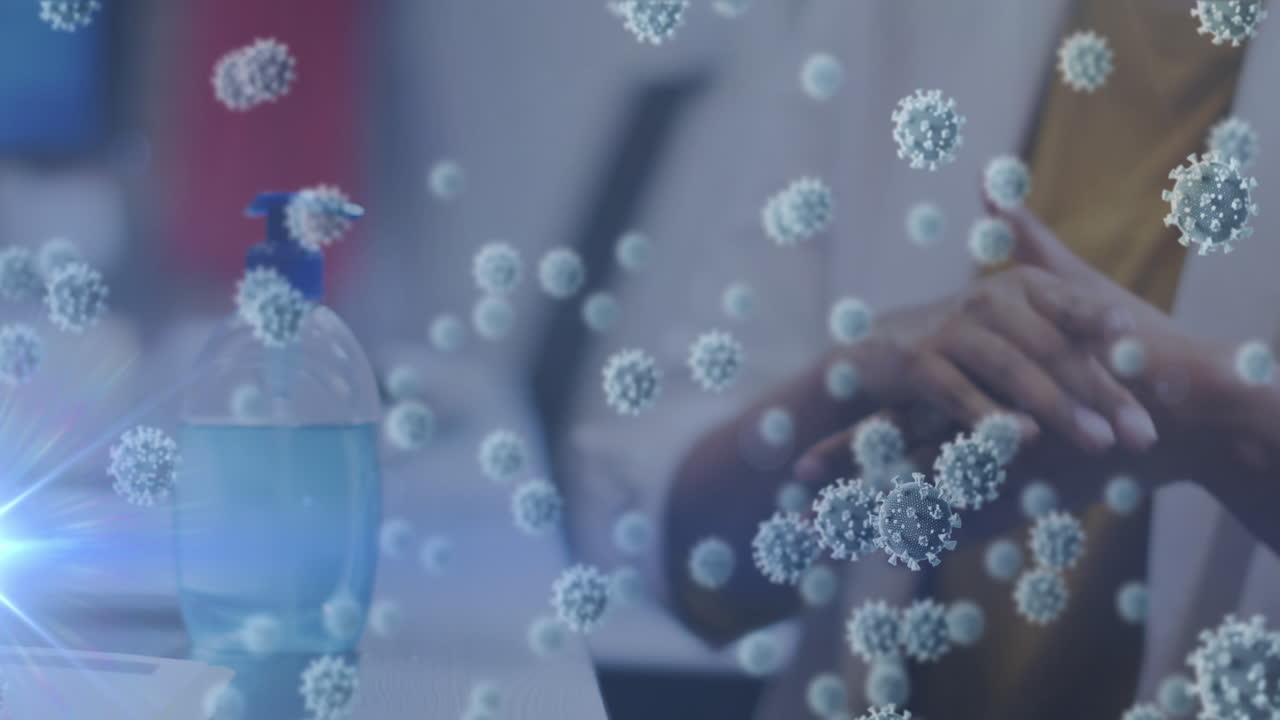 사무실에서 손을 소독하는 여성의 중간 부분 위에 떠다니는 코로나 19 세포의 애니메이션