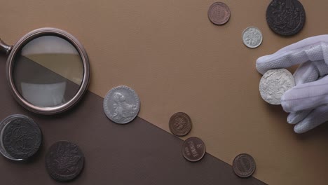 numismática. antiguas monedas de colección hechas de plata en una mesa de madera.