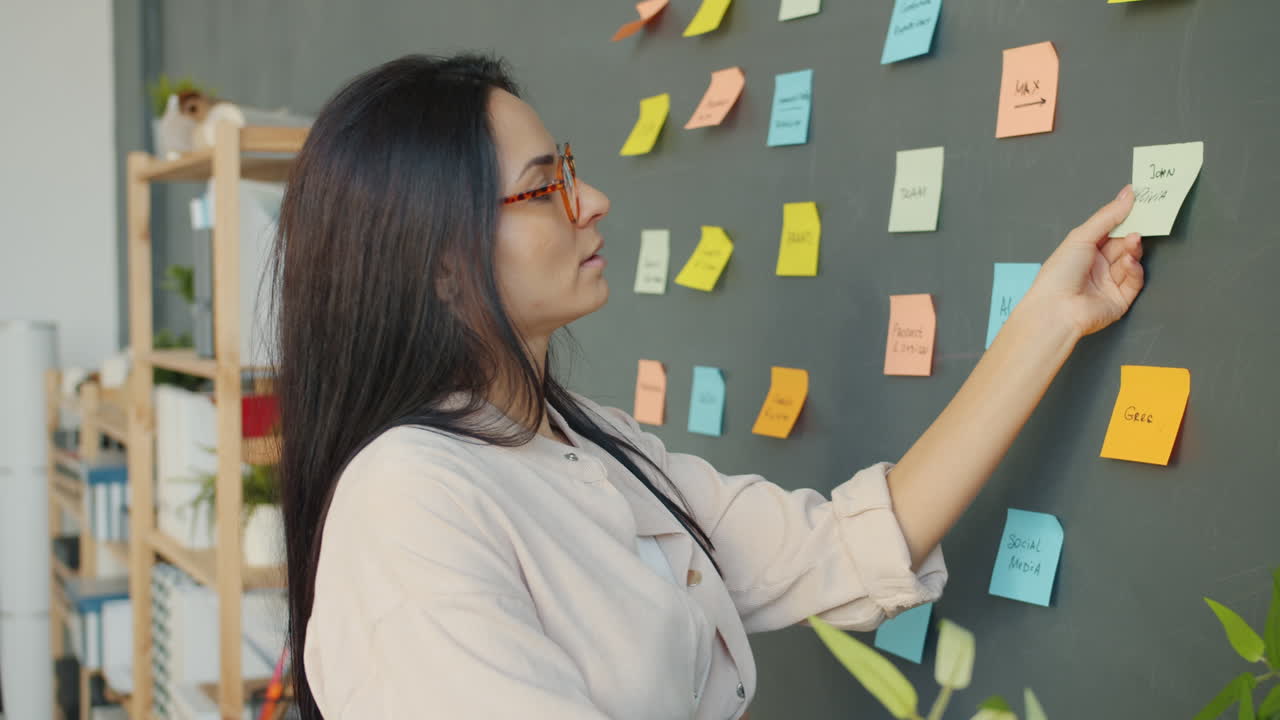 Woman Planning a Project on a Wall with Sticky Notes