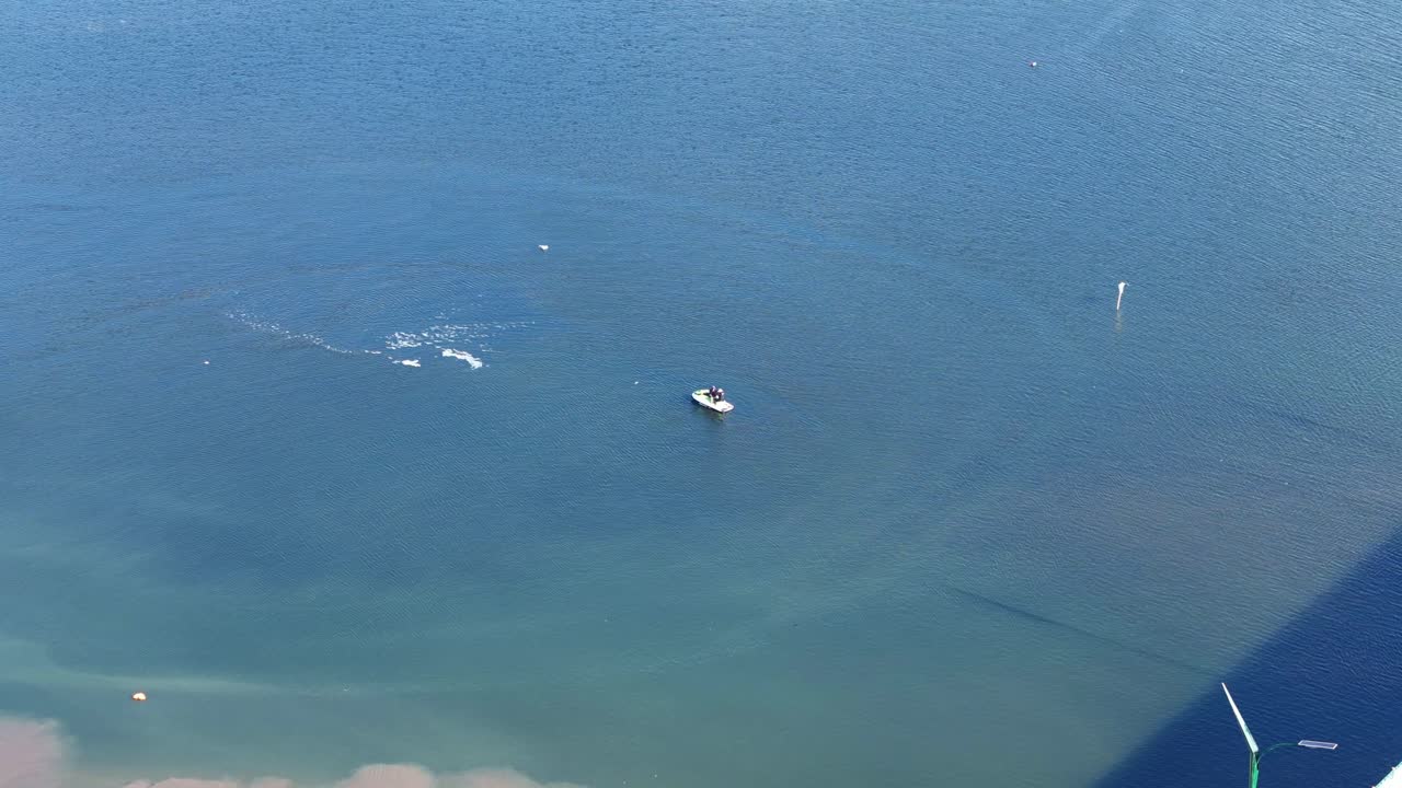 Aerial view of people is ridding on the Personal watercraft (PWC) floating on the calm sea water surface. Jet ski, Wave Runner. 4K drone footage.