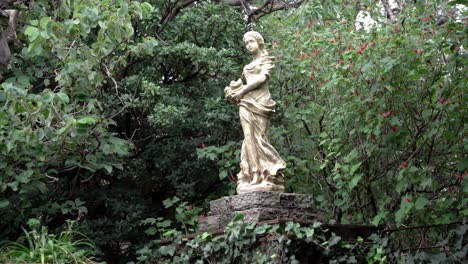 a sculpture of a woman in the middle of the forest