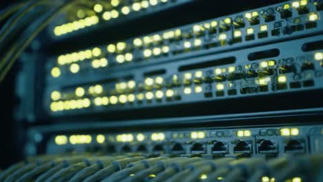 wires connect multiple servers as lights illuminate the network equipment inside a modern data center. the video showcases advanced technology and complex infrastructure.