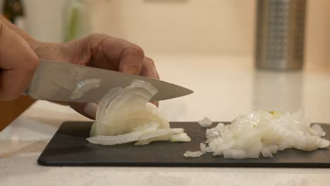 Woman's-Hands-Knife-Chop-Onion-on-Cutting-Board-on-Kitchen-Bench-CLOSE