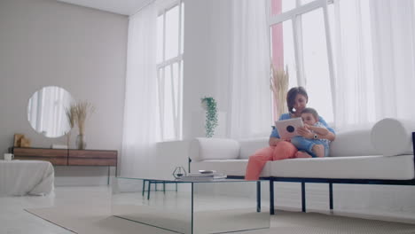 Mother-and-son-playing-with-digital-tablet-at-home.-Young-mother-with-her-5-years-old-smiling-with-digital-tablet-at-home