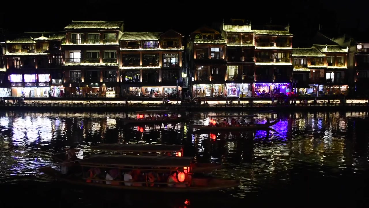 Vista noturna da Cidade Antiga de Fenghuang na Província de Hunan, China, destacando seu encanto histórico com arquitetura chinesa tradicional, casas sobre palafitas, ruas de paralelepípedos e paisagens ribeirinhas.