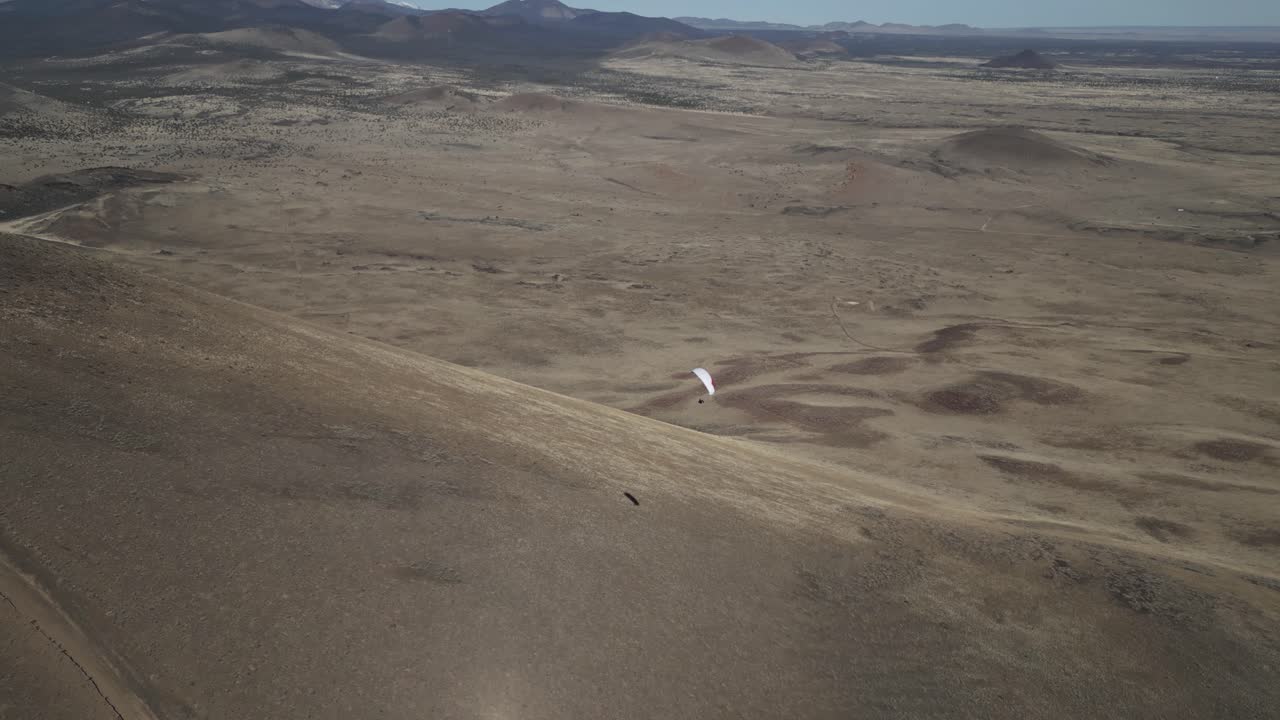 Paraglider In Flight Over Desert Landscape Near Flagstaff In Arizona, USA. orbiting drone shot